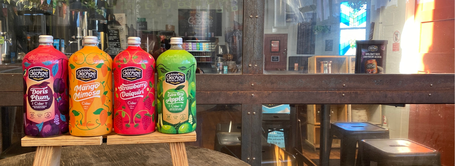 Row of colorful bottles on a wooden stand with a blurred indoor background