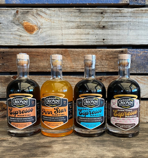 Four bottles of George Dickel brand spirits on a wooden surface with a rustic background.