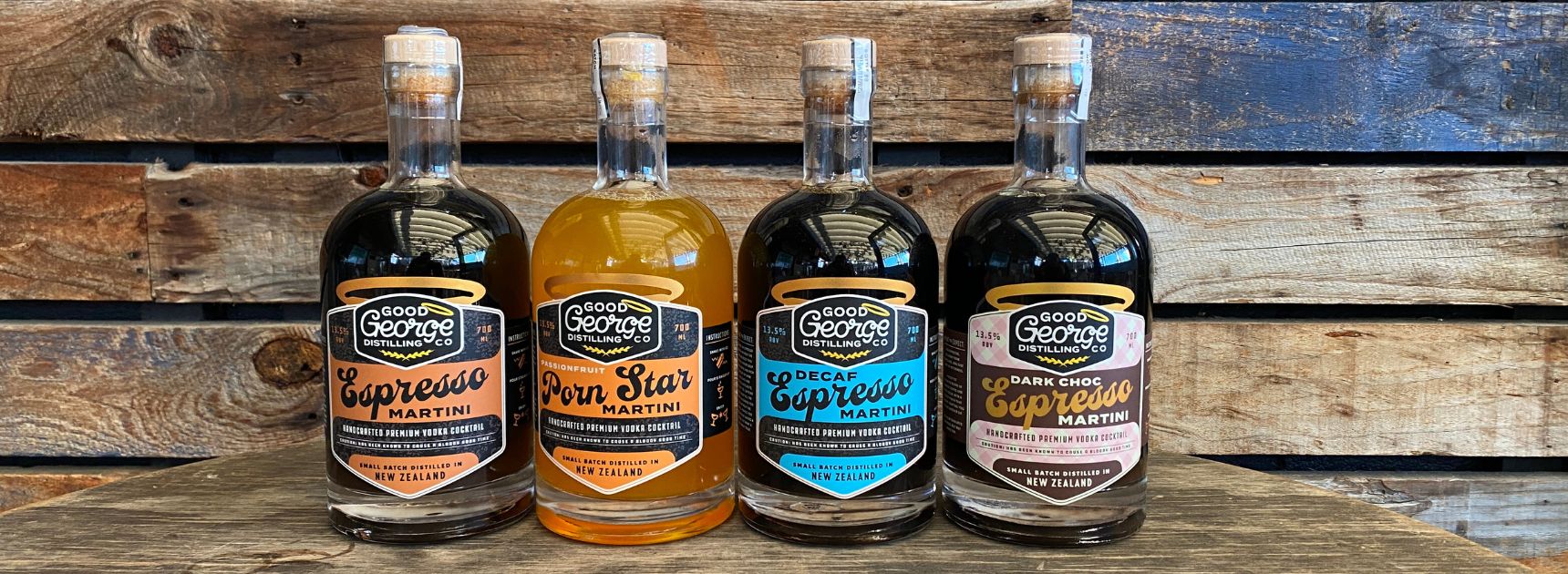 Four bottles of Captain Mullen's Malt Whiskey on a wooden surface