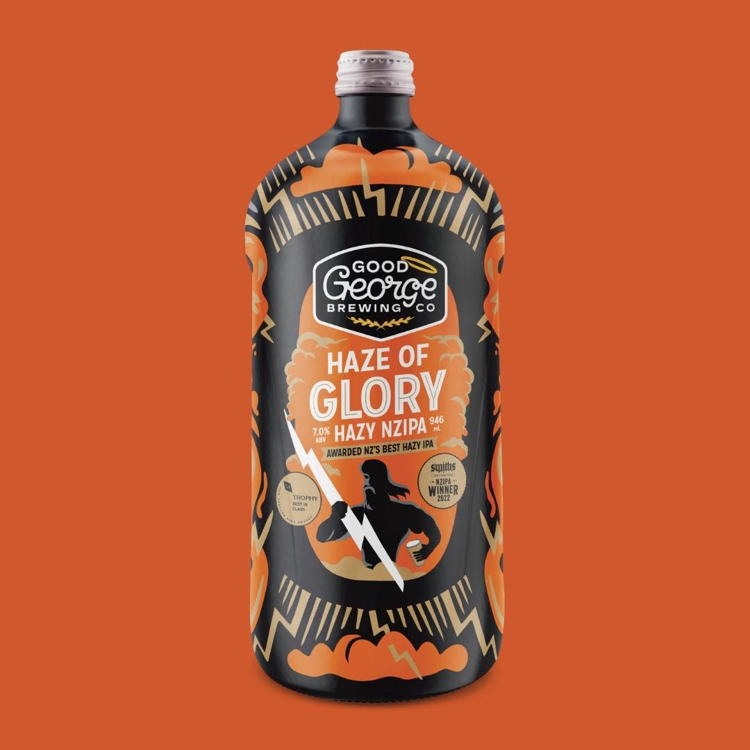 A bottle of Haze of Glory Hazy NZIPA beer with a decorative label featuring a black and orange color scheme.