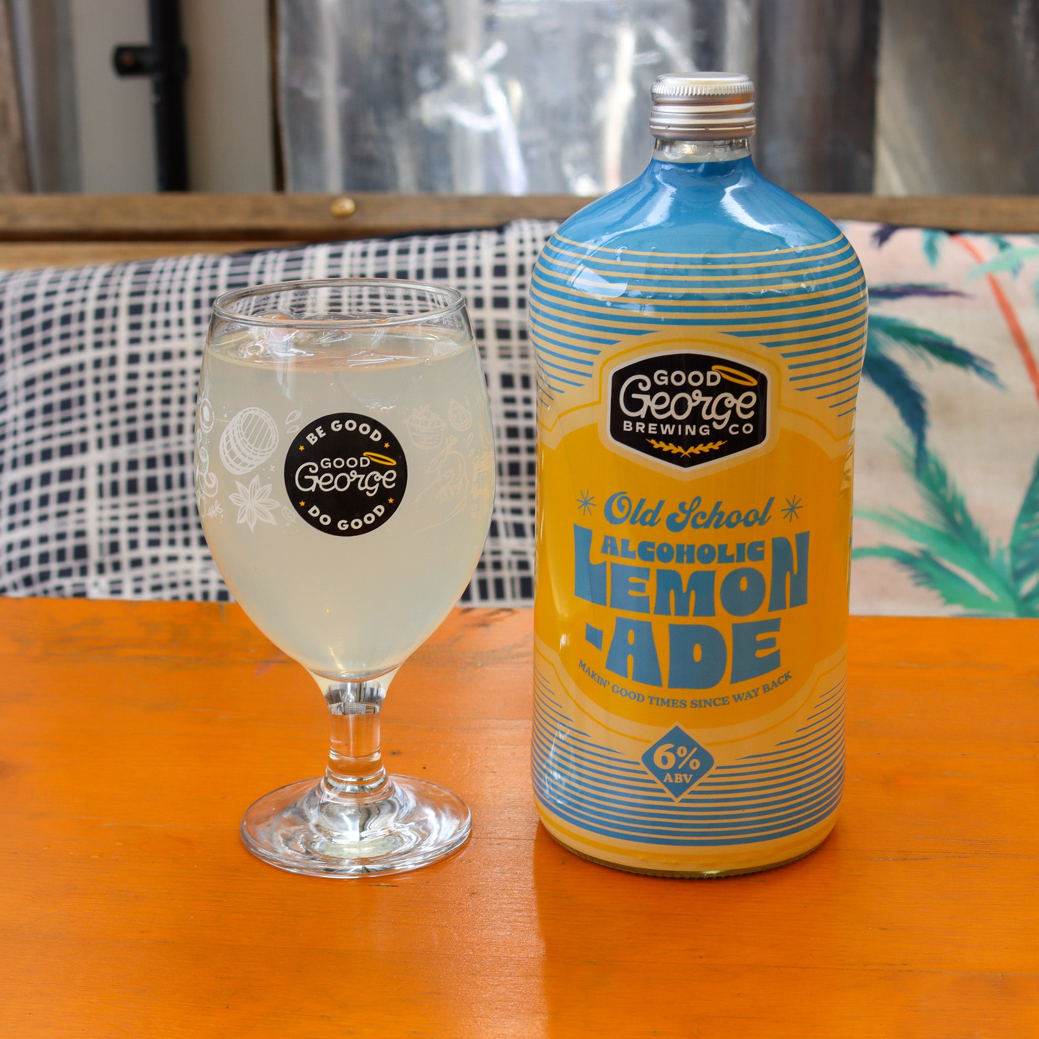 A bottle of Good George Old School Alcoholic Lemonade with glass on lemonade next to it.