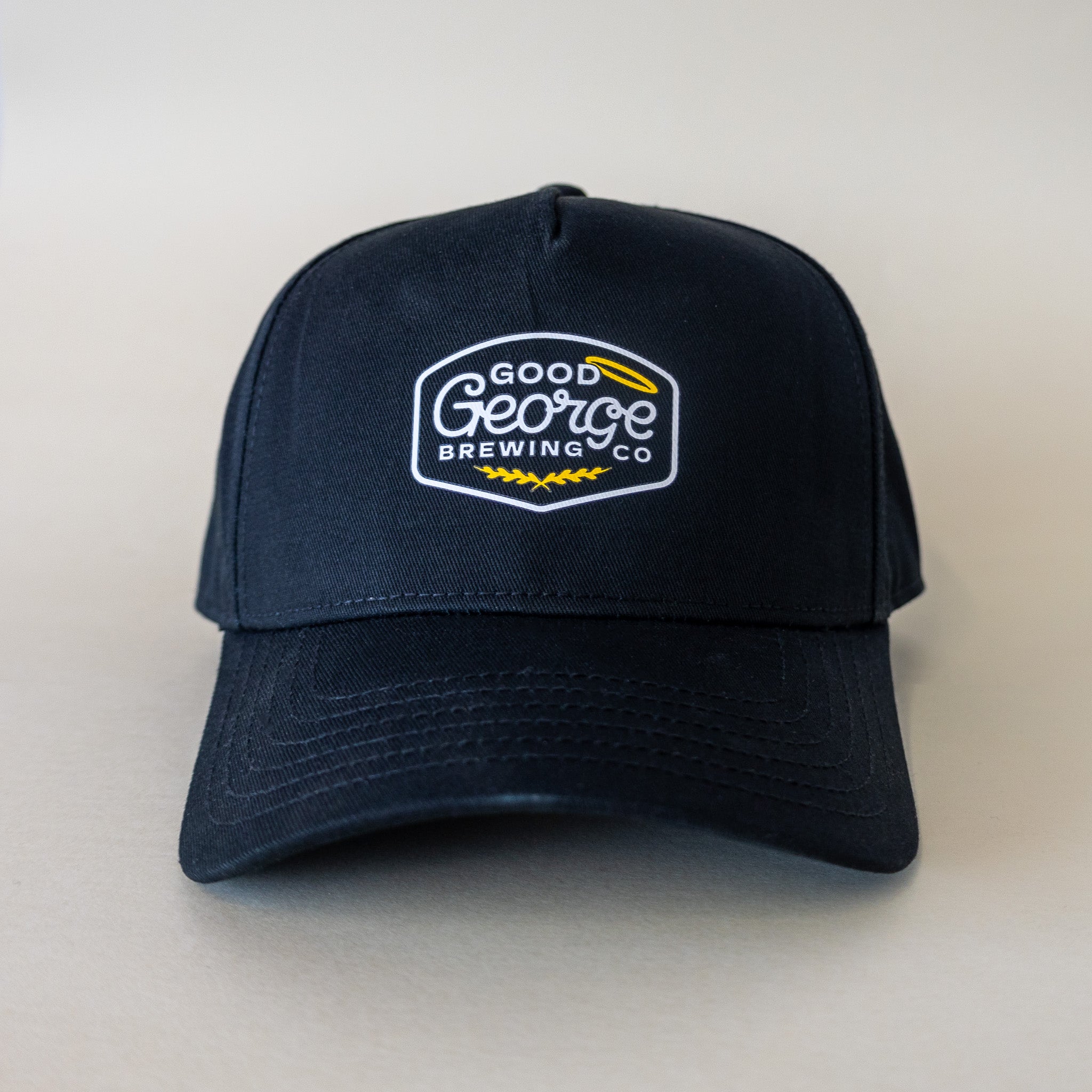 A black George snapback cap with a curved peak and an embroidered logo on the front.