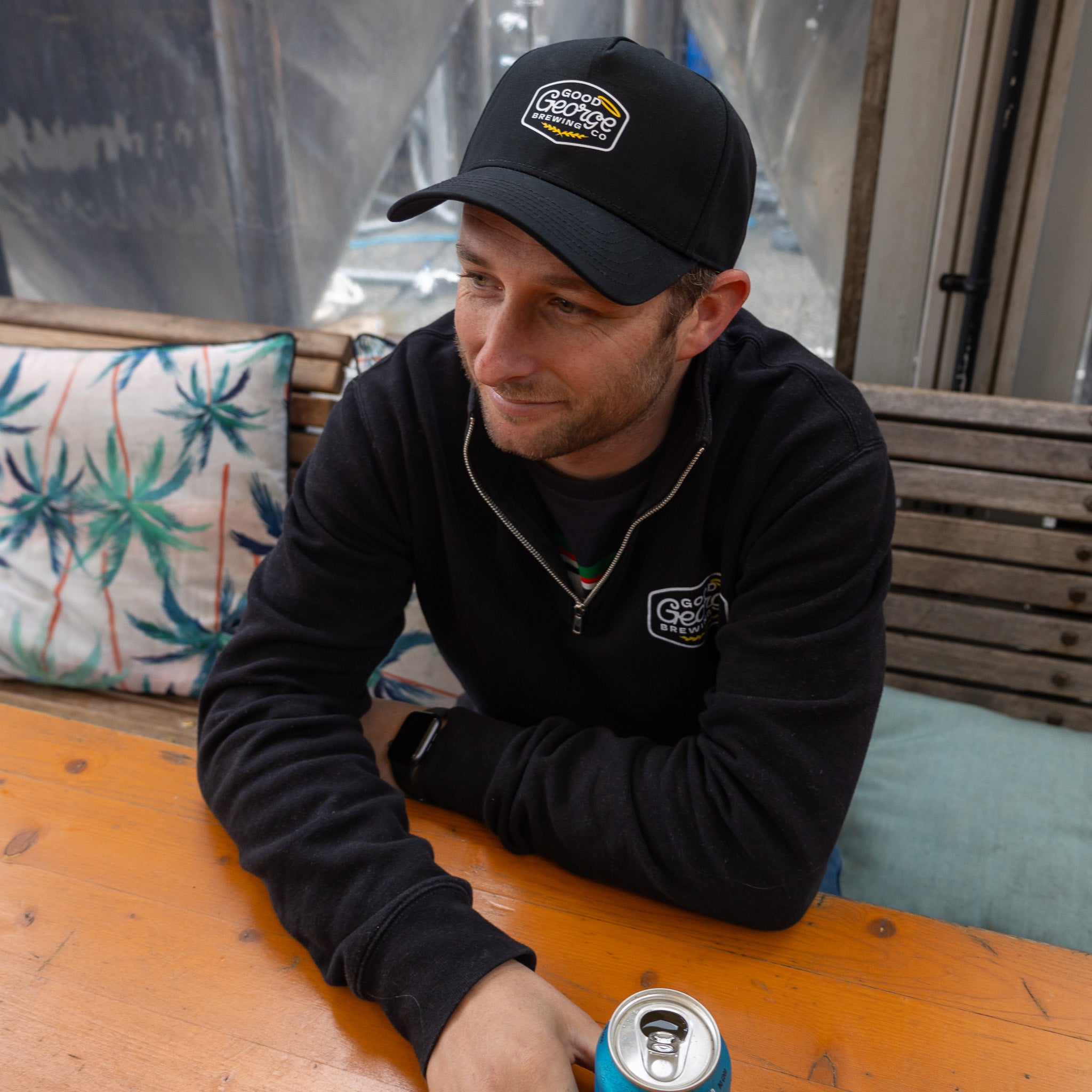 A black George snapback cap with a curved peak and an embroidered logo on the front.