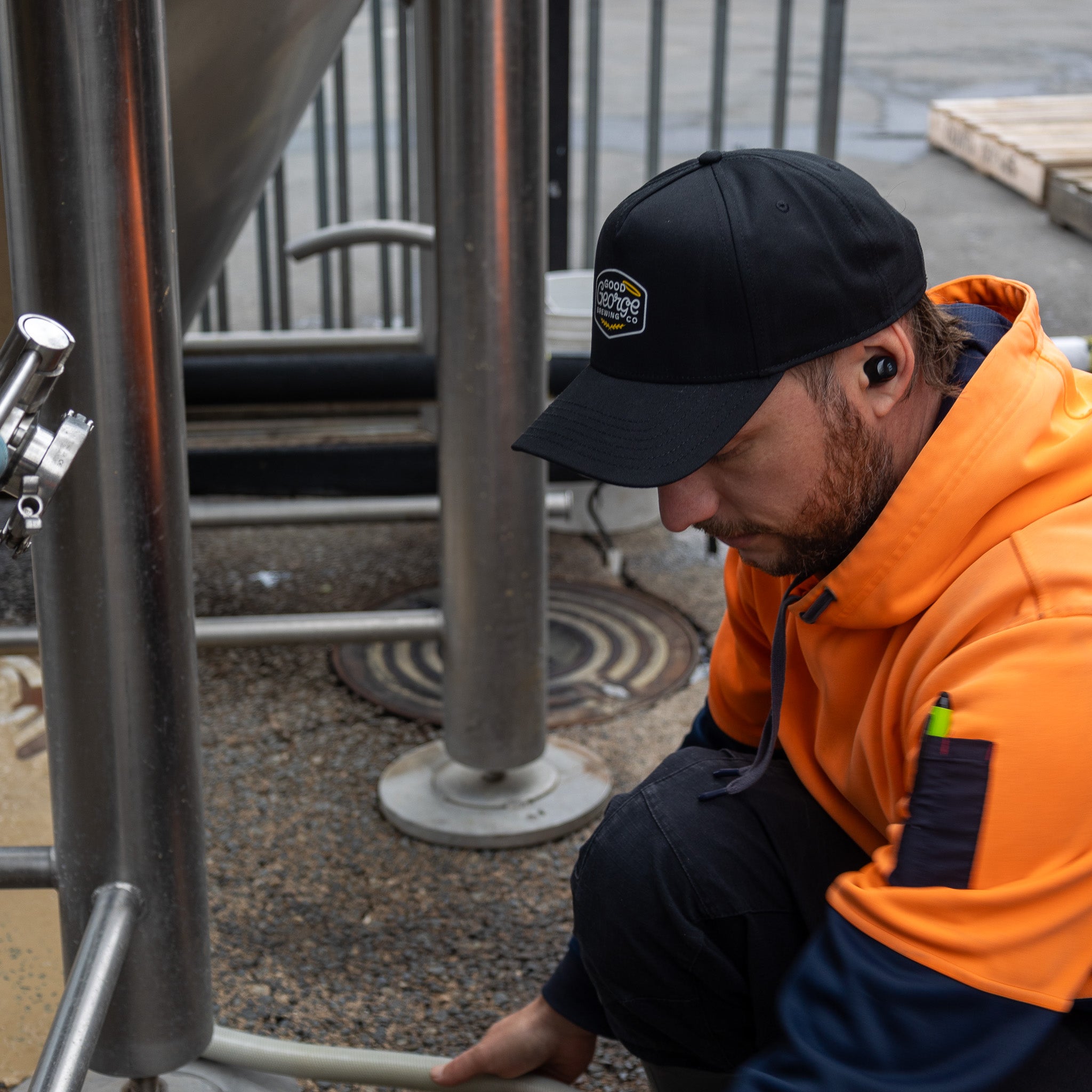 A black George snapback cap with a curved peak and an embroidered logo on the front.