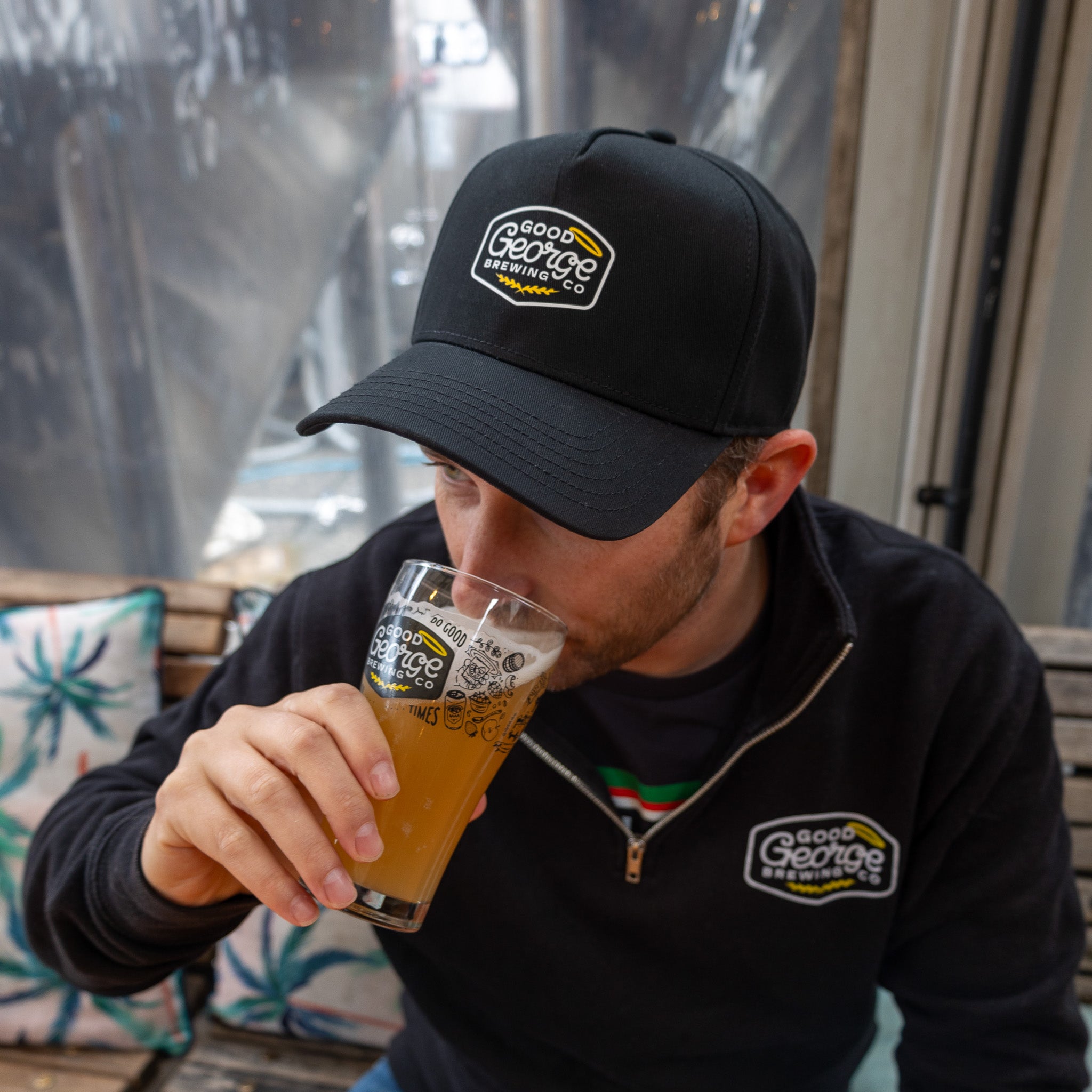 A black George snapback cap with a curved peak and an embroidered logo on the front.