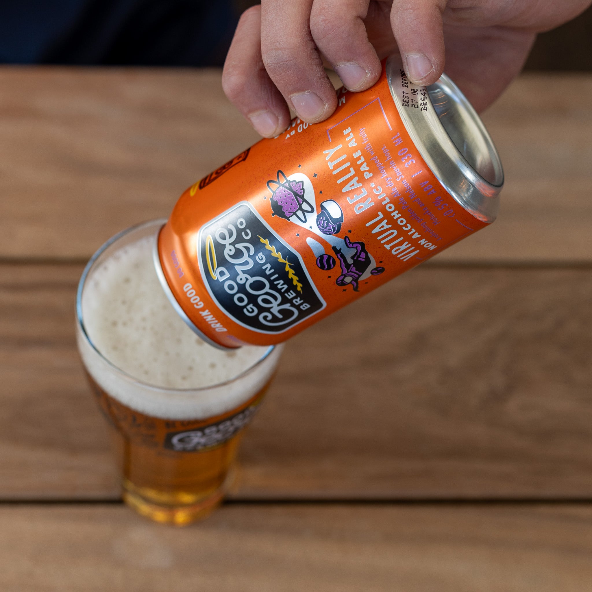 A can of Virtual Reality Non-Alcoholic Pale Ale by Good George Brewing Co. is getting poured into a beer glass