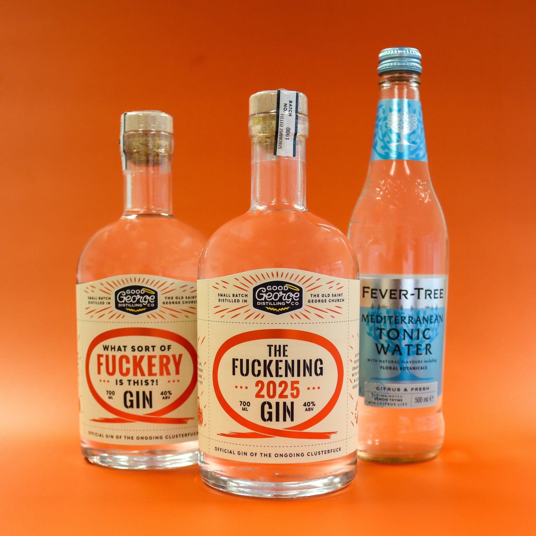 Three bottles of gin and tonic on an orange background