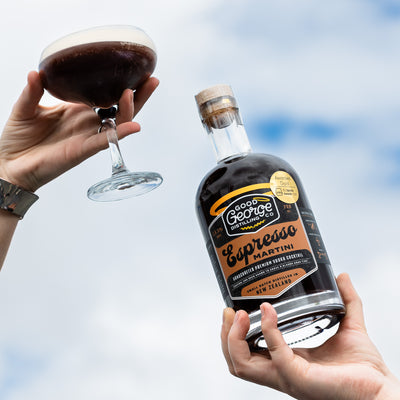 Bottle of Good George Espresso Martini with a glass of the cocktail against a blue sky background