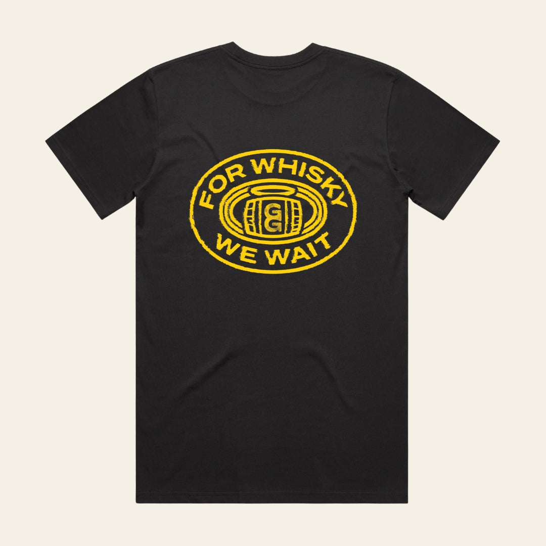 Black t-shirt with yellow 'For Whisky We Wait' graphic on a beige background