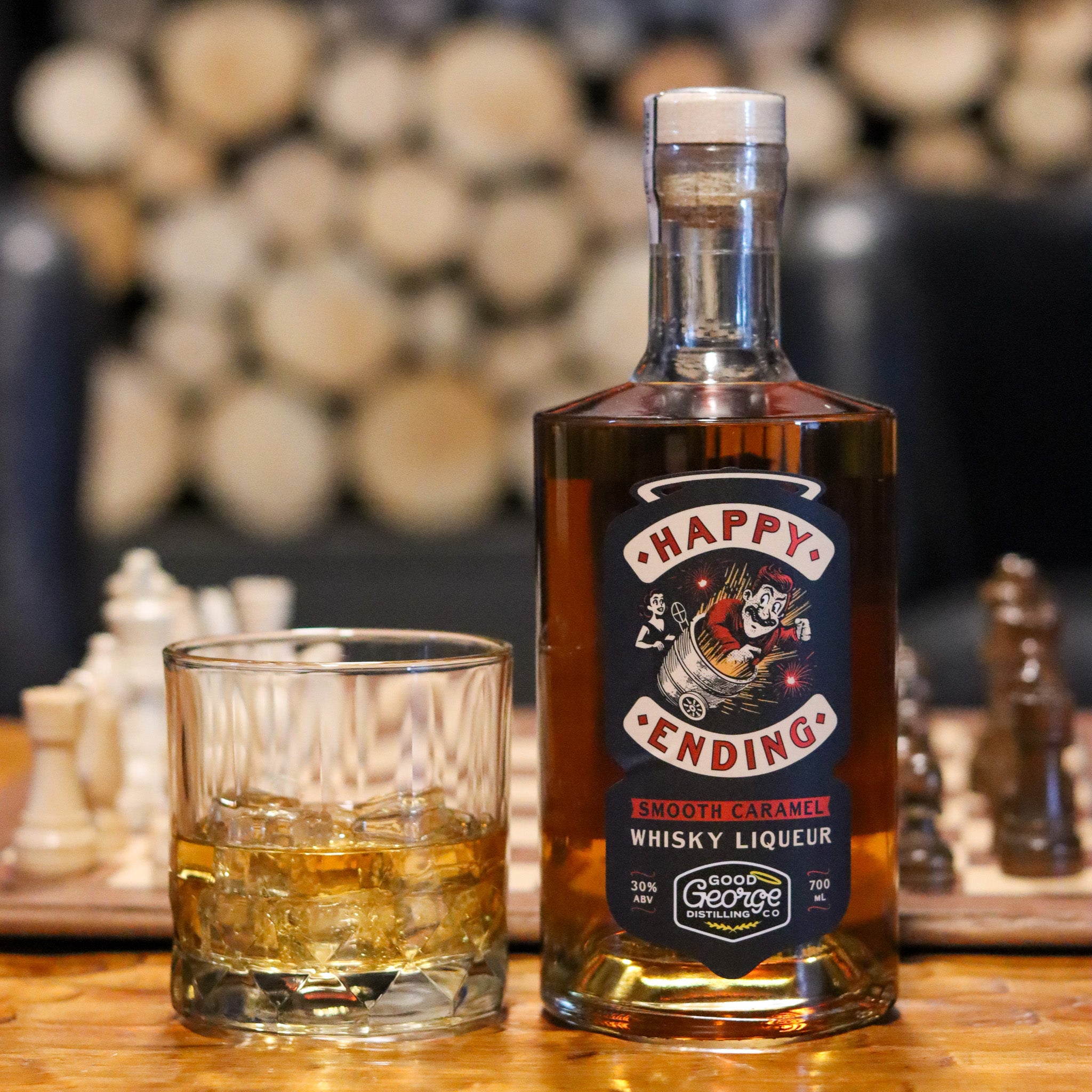 Bottle of 'Happy Ending' whisky liqueur with a glass on a wooden surface, blurred background