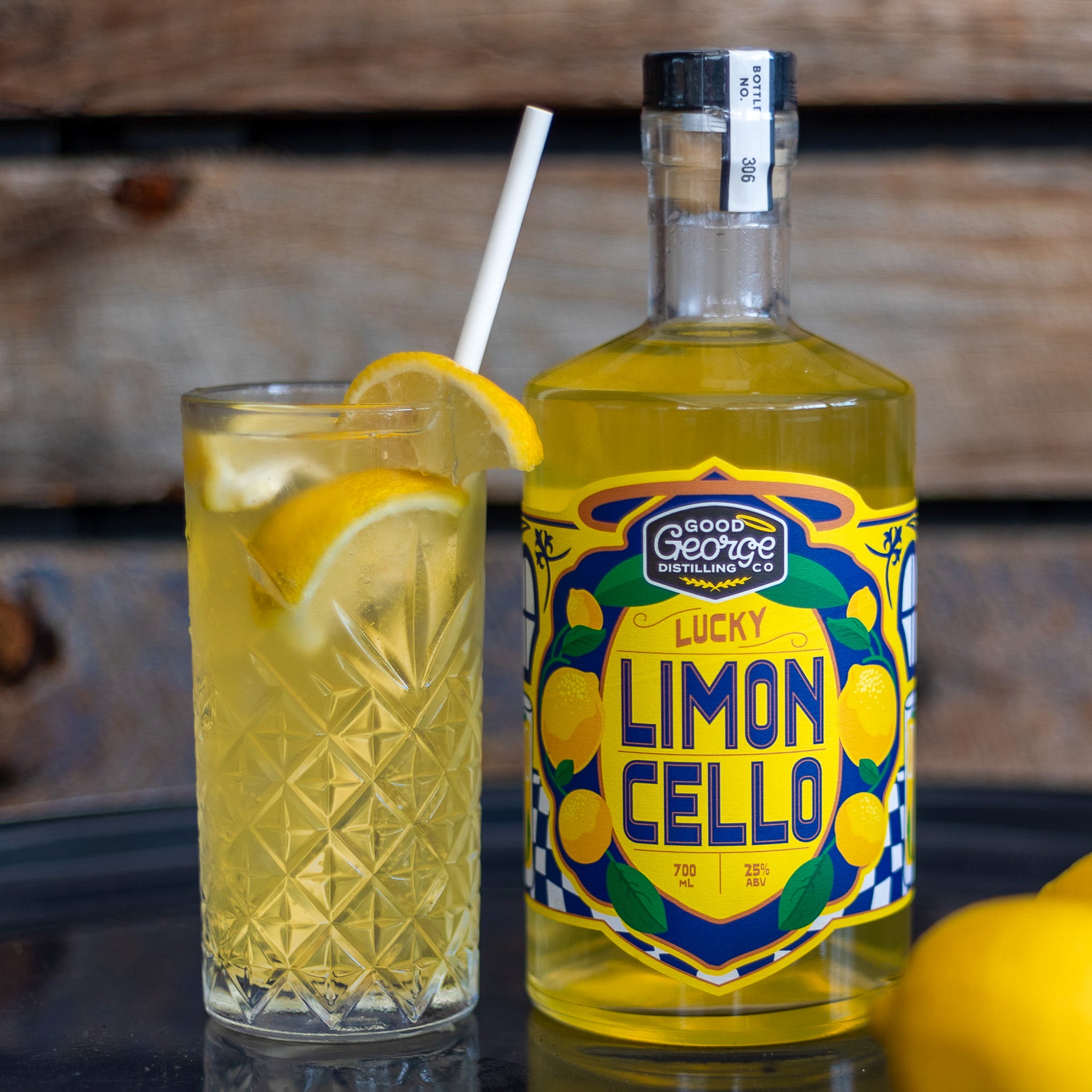 Bottle of Lucky Limoncello with a cocktail garnished with lemon slices on a wooden surface.