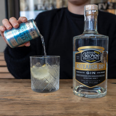 A can of tonic getting poured into a glass to make a G&T