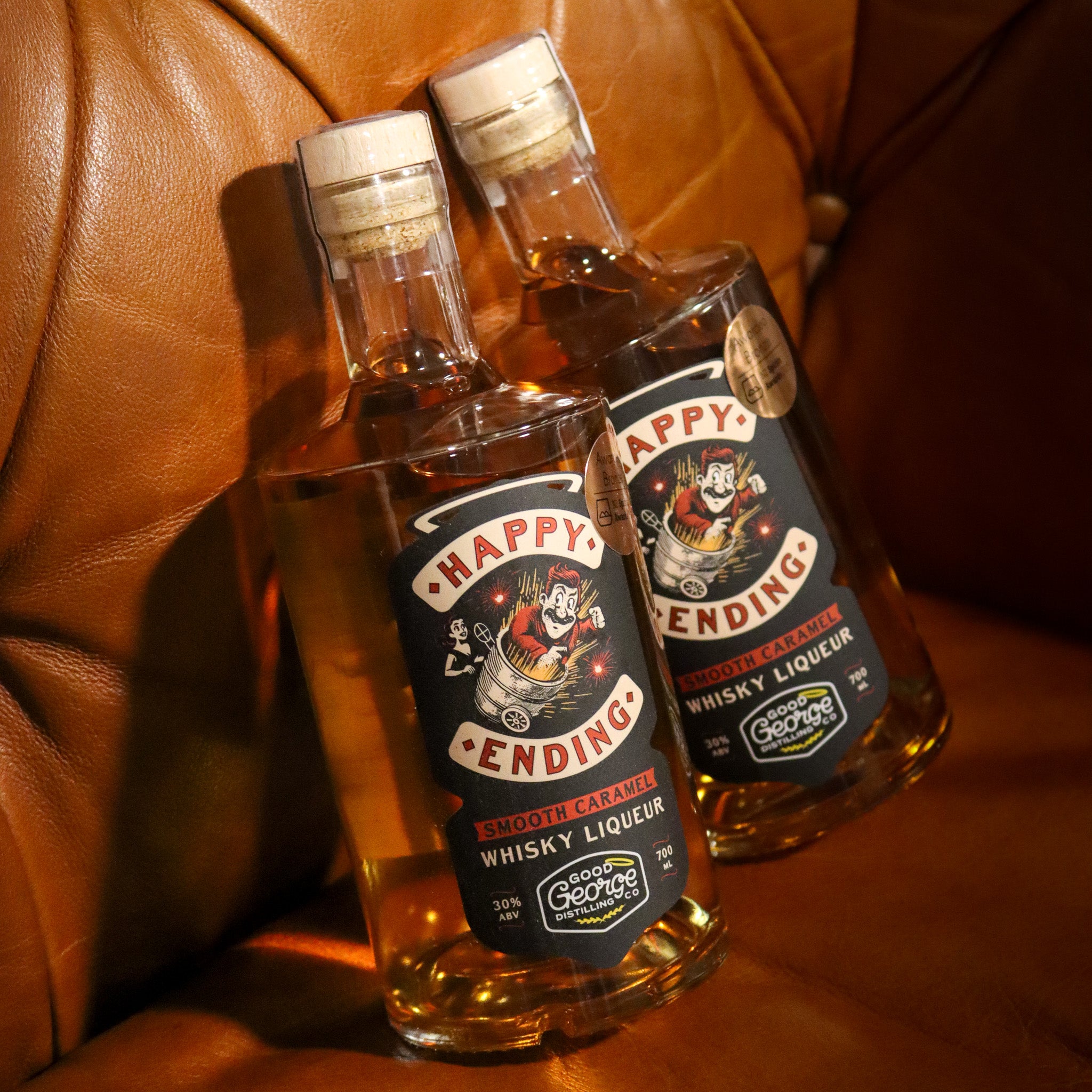 Two bottles of Happy Ending Whisky Liqueur on a brown leather surface