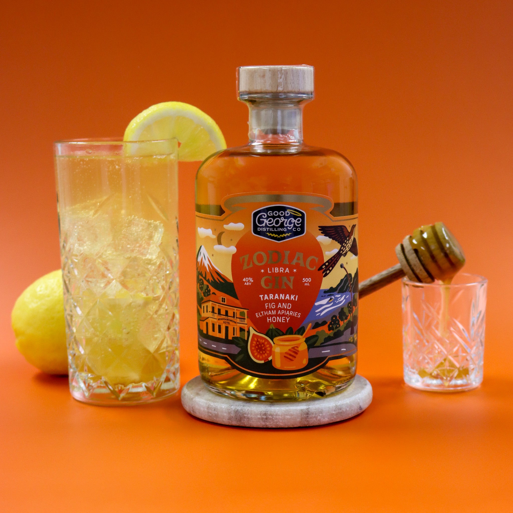 Bottle of George's Lottiac Gin with a glass of lemonade and honey on an orange background