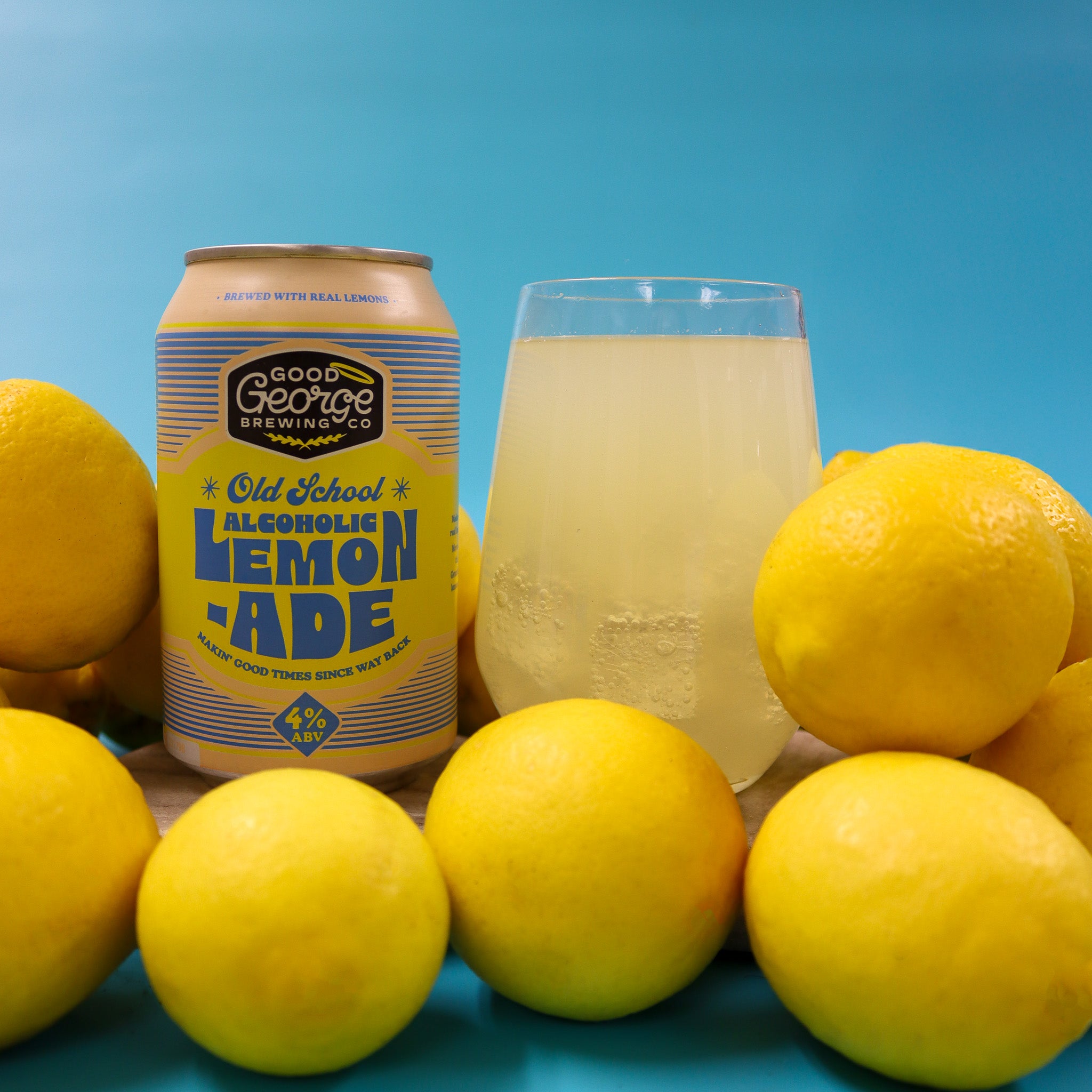 Good George Brewing lemonade can with a glass of lemonade and lemons on a blue background