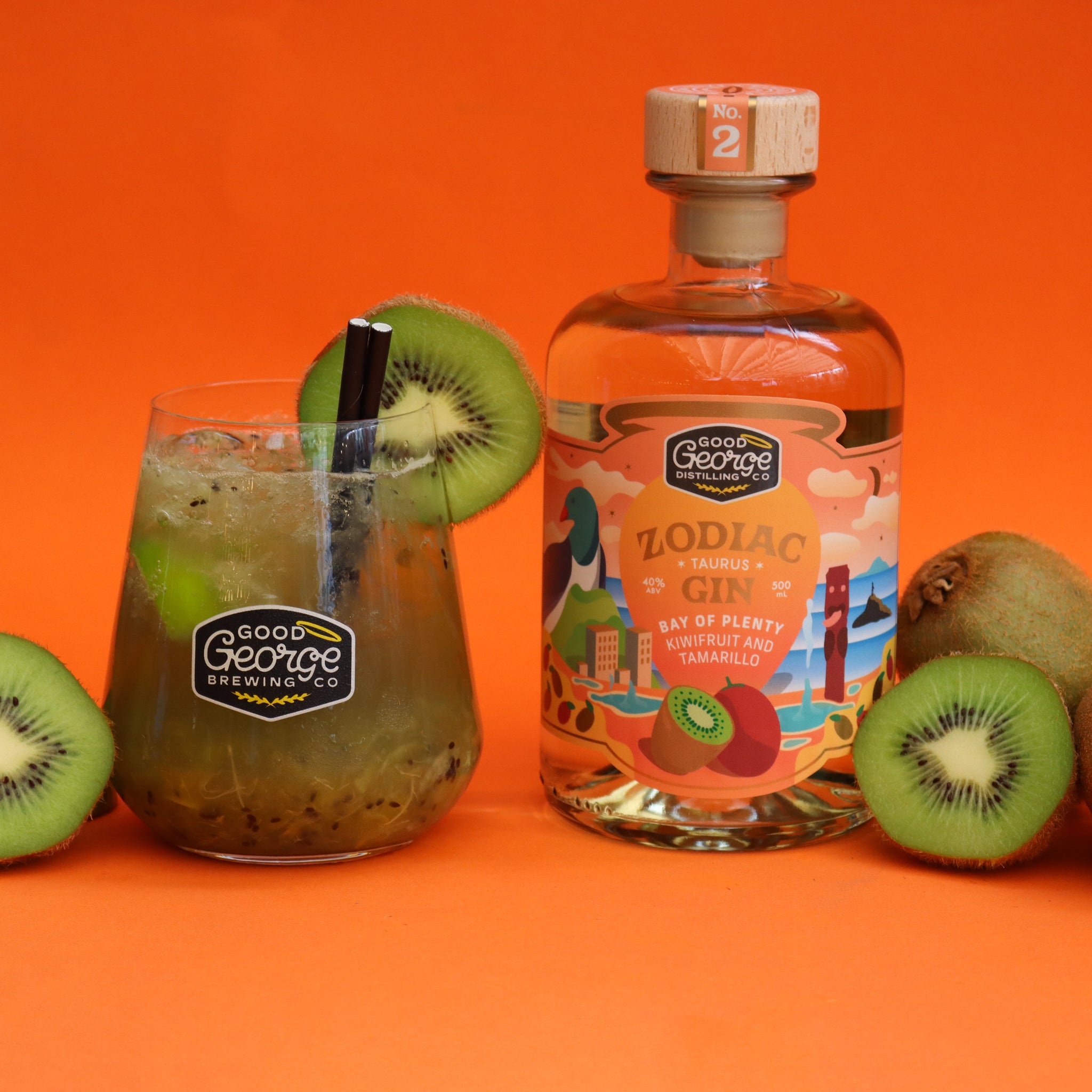 A bottle of Taurus Kiwifruit and Tamarillo Gin 500ml with a label featuring illustrations of a kiwifruit and tamarillo. A kiwifruit cocktail next to it with sliced kiwifruit around it on a orange background