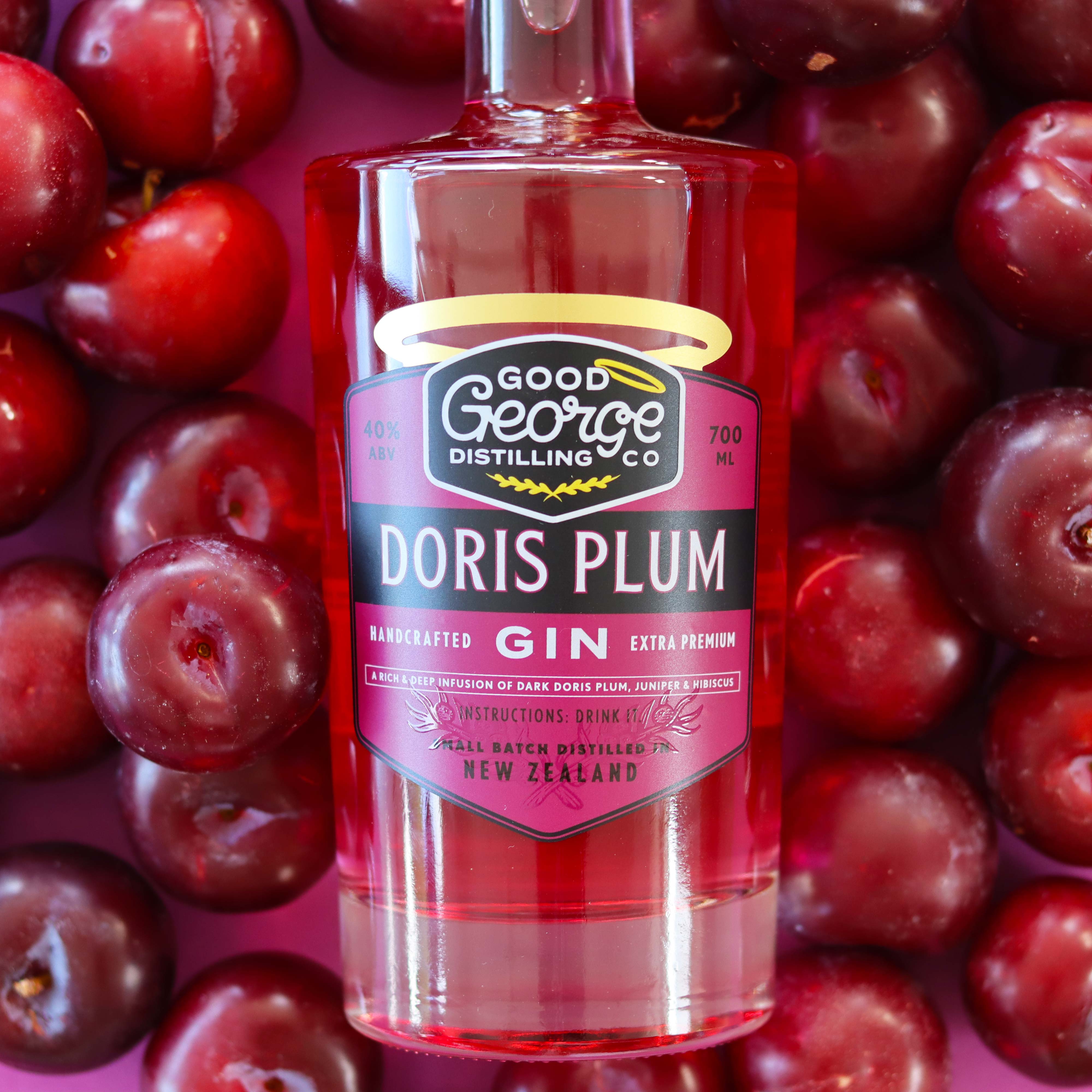Good George Doris Plum Gin 700ml Bottle surrounded by fresh plums