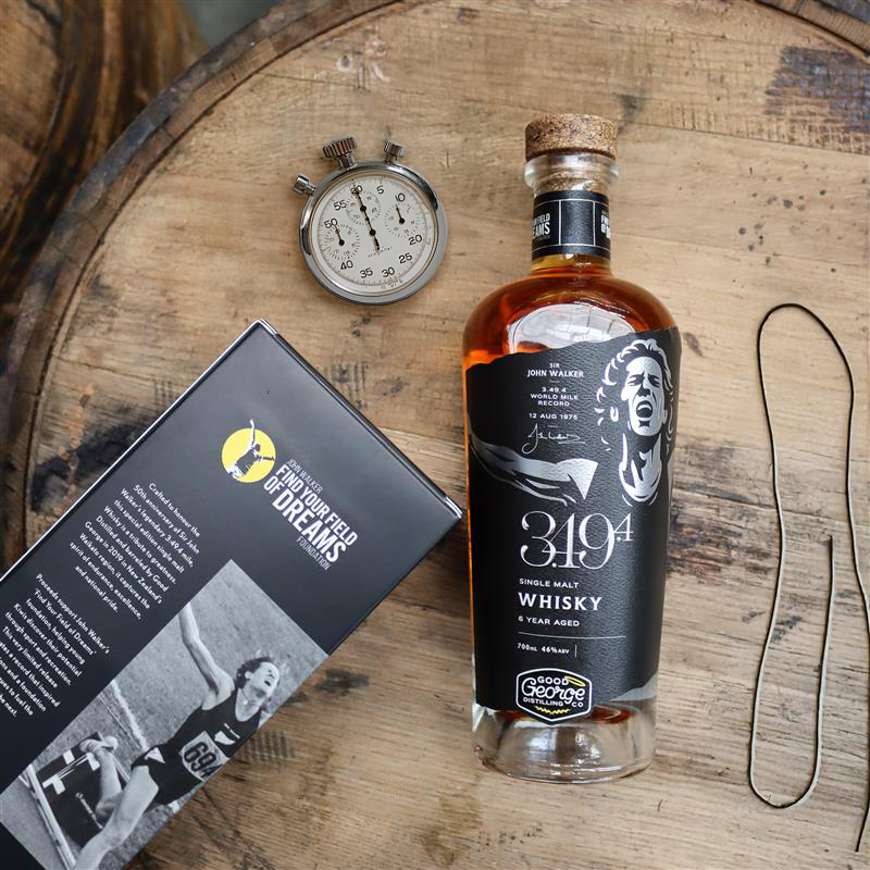 Bottle of 3.49.4 Whisky on a wooden surface with a stopwatch and old shoe lace