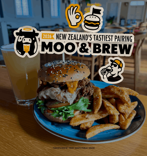A plated burger with fries on a blue plate, a glass of beer, and several overlaid promotional stickers reading '2026 New Zealand's Tastiest Pairing Moo & Brew' on a restaurant table.