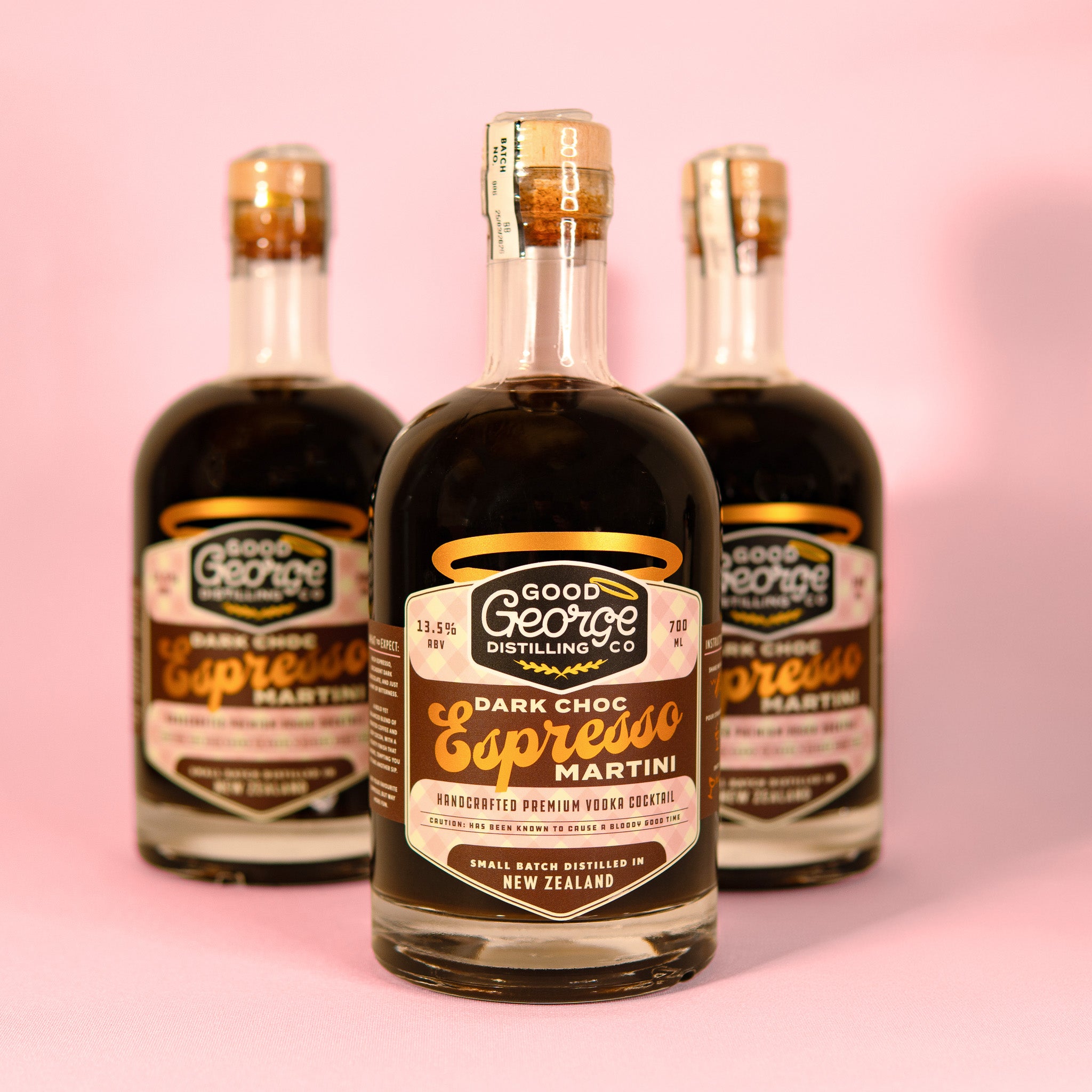 Three bottles of Good George Distilling Co. Dark Choc Espresso Martini on a pink background