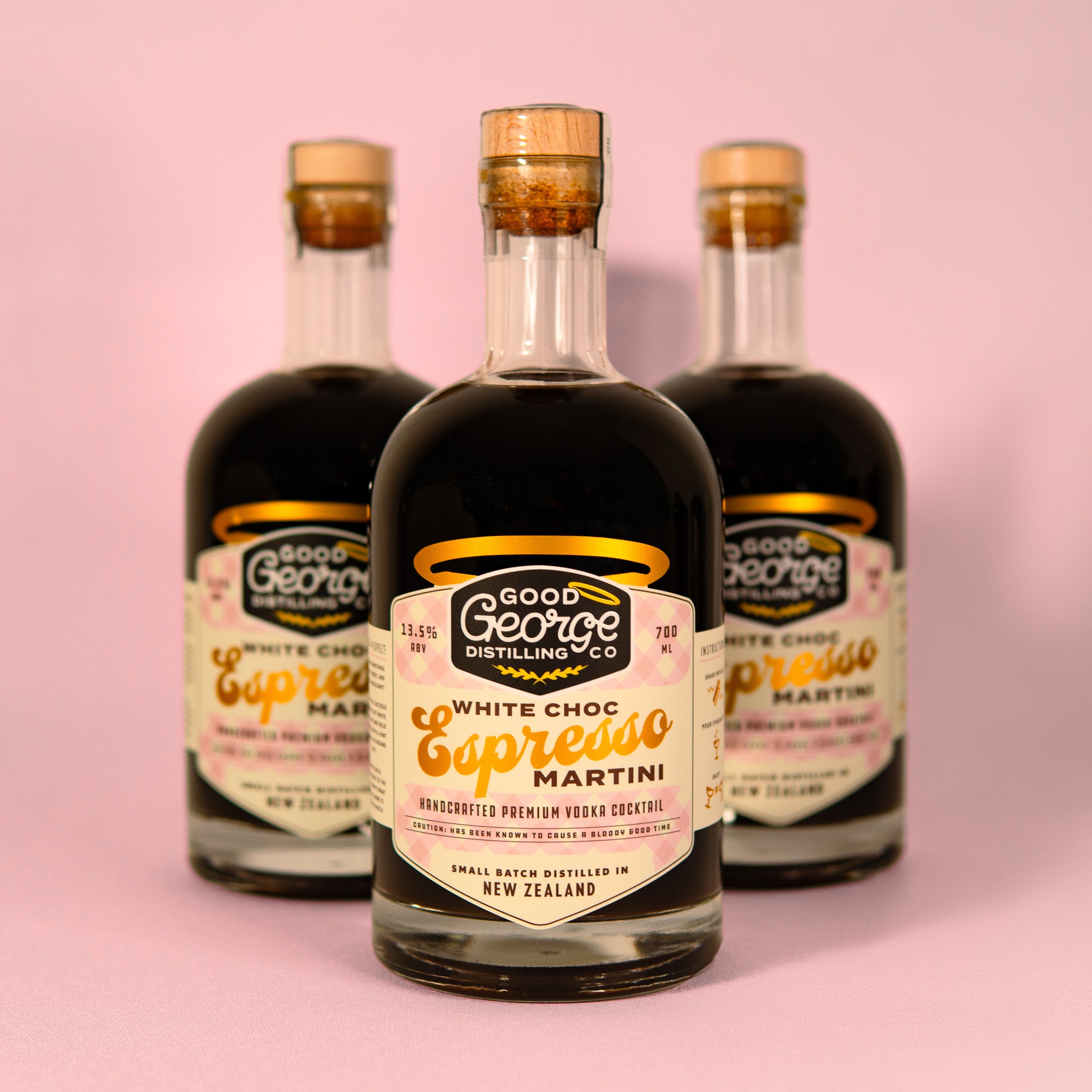 Three bottles of Good George Distilling Co. White Choc Espresso Martini on a pink background