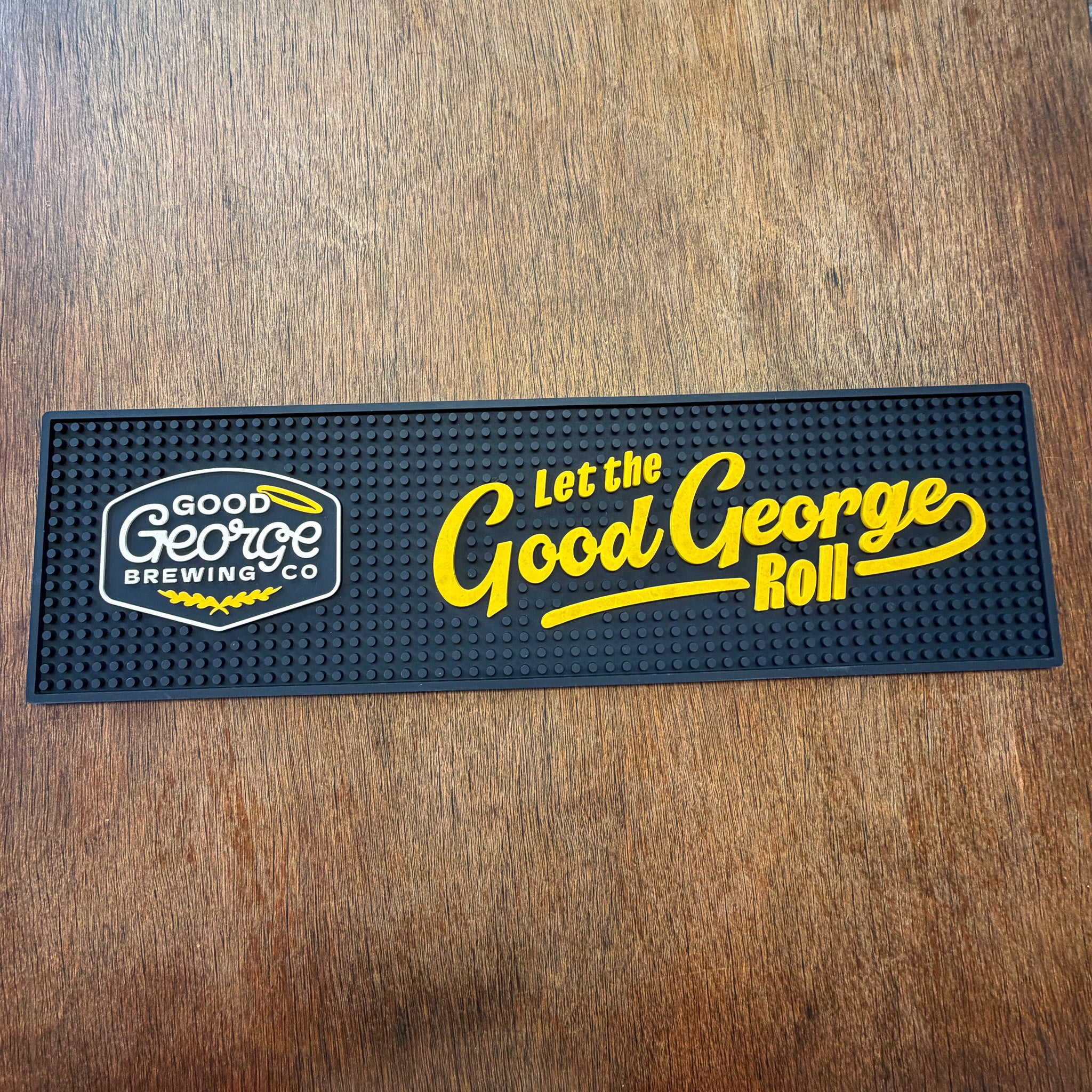 Good George Brewing Co bar mat with text on a wooden surface