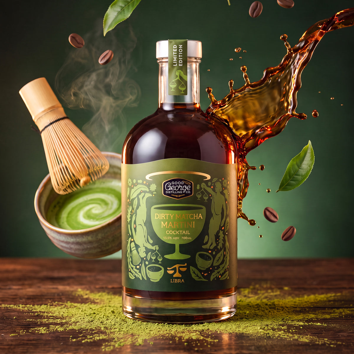 A bottle of Good George Dirty Matcha Martini Cocktail liqueur is centered on a wooden surface, surrounded by a green matcha whisk, green tea swirl, coffee beans, and a dramatic splash of dark amber liquid against a dark green background.