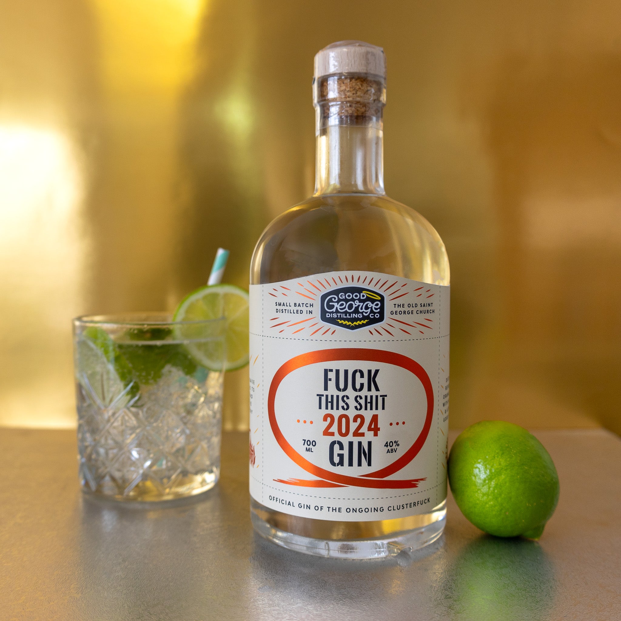 The image features a clear glass bottle of "Fuck This Shit 2024 Gin" with a bold, red label that reads "FUCK THIS SHIT 2024 GIN" in large, capital letters. The gin is presented in a classic, elegant style with a distinctive red and gold label, emphasizing its premium quality.