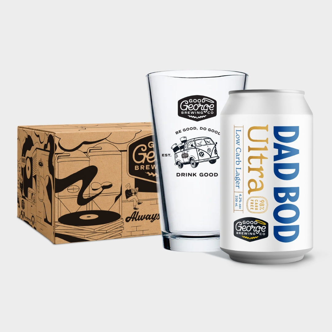 A set of Good George Brewing Co. products including a white can labeled 'DAD BOD Ultra', a clear glass tumbler with black and white graphics, and a brown cardboard shipping box with black illustrations, all arranged on a light gray background.