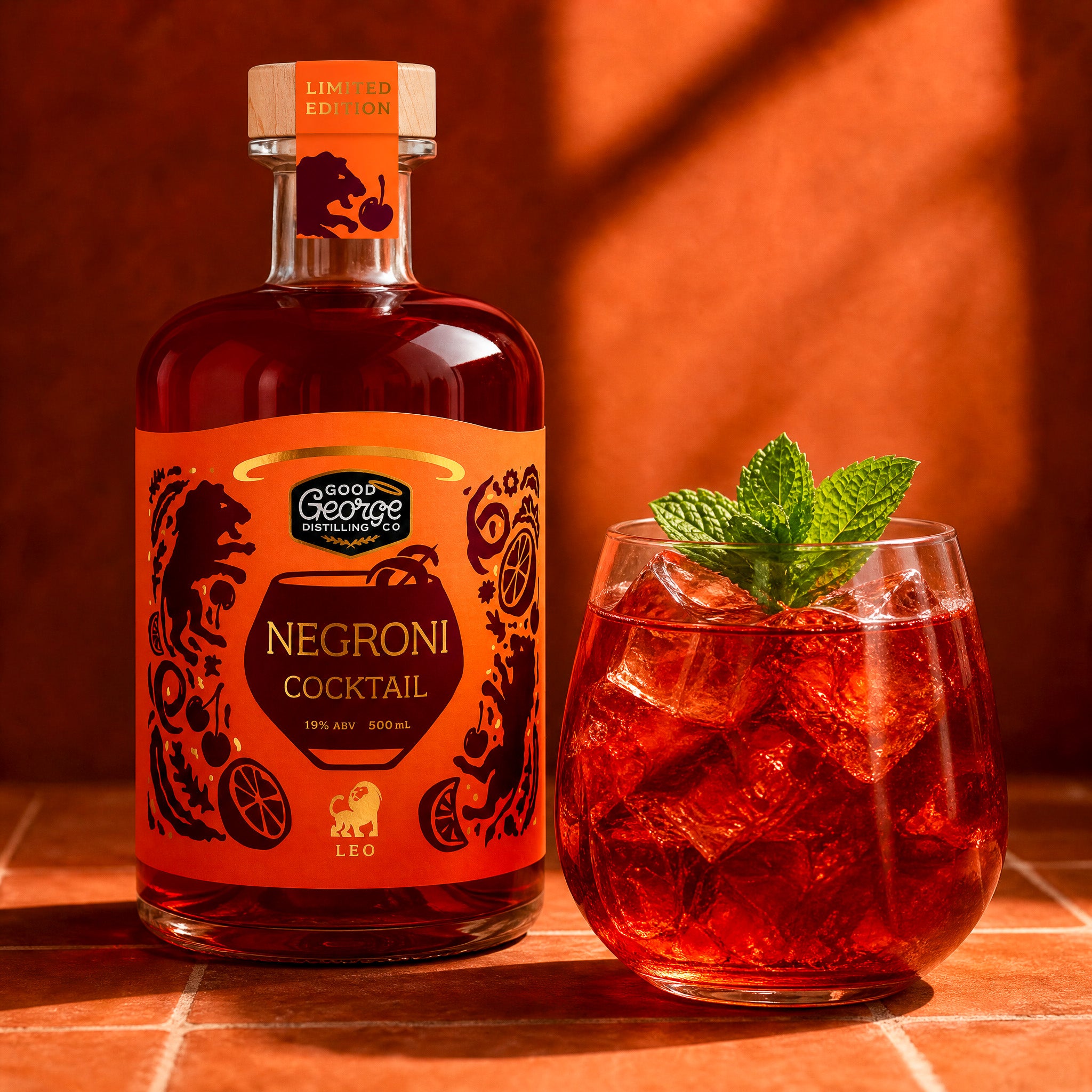 Bottle of Negroni cocktail and a glass with ice and a mint leaf on a warm-toned background