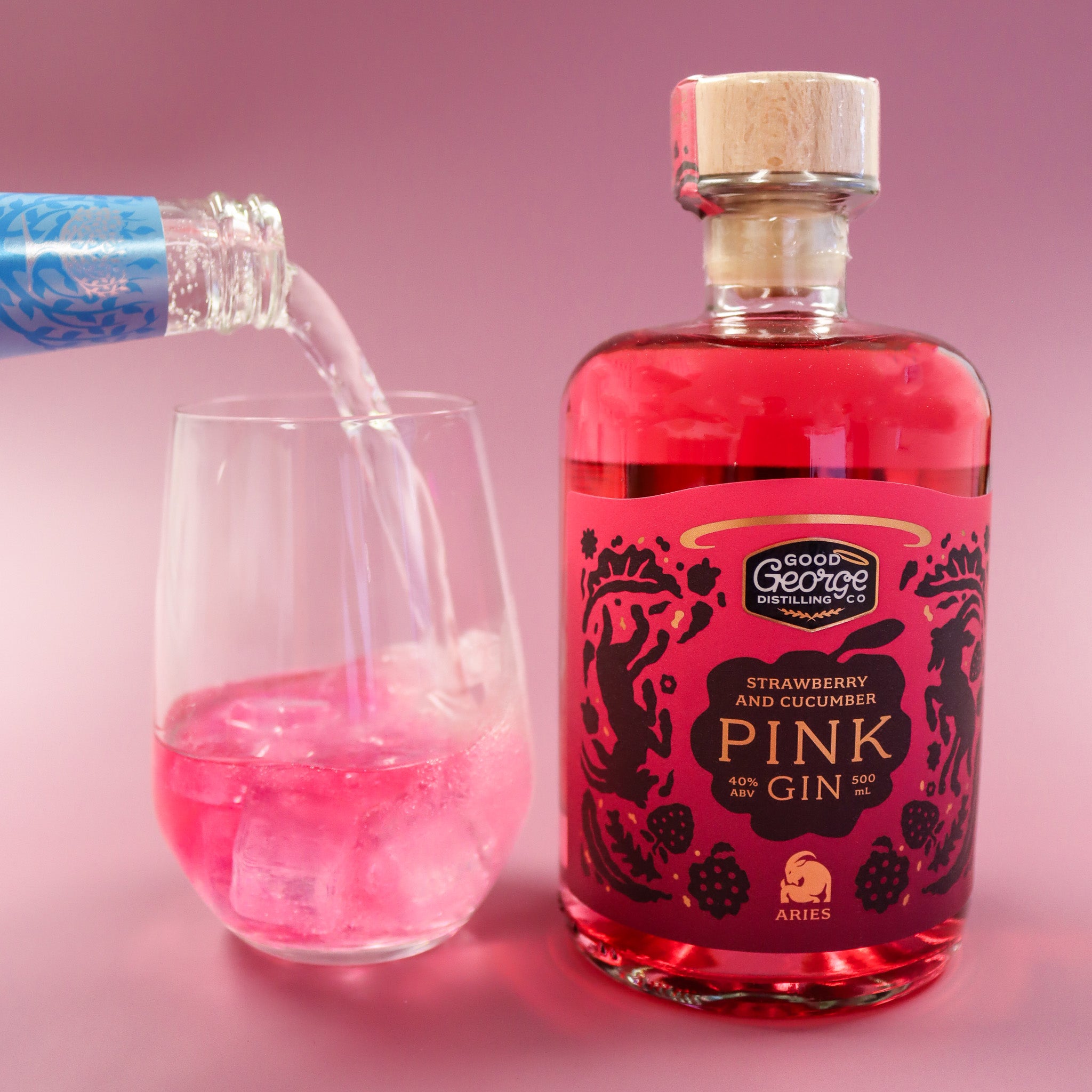 Bottle of Good George Pink Gin with a glass filled with pink liquid on a pink background