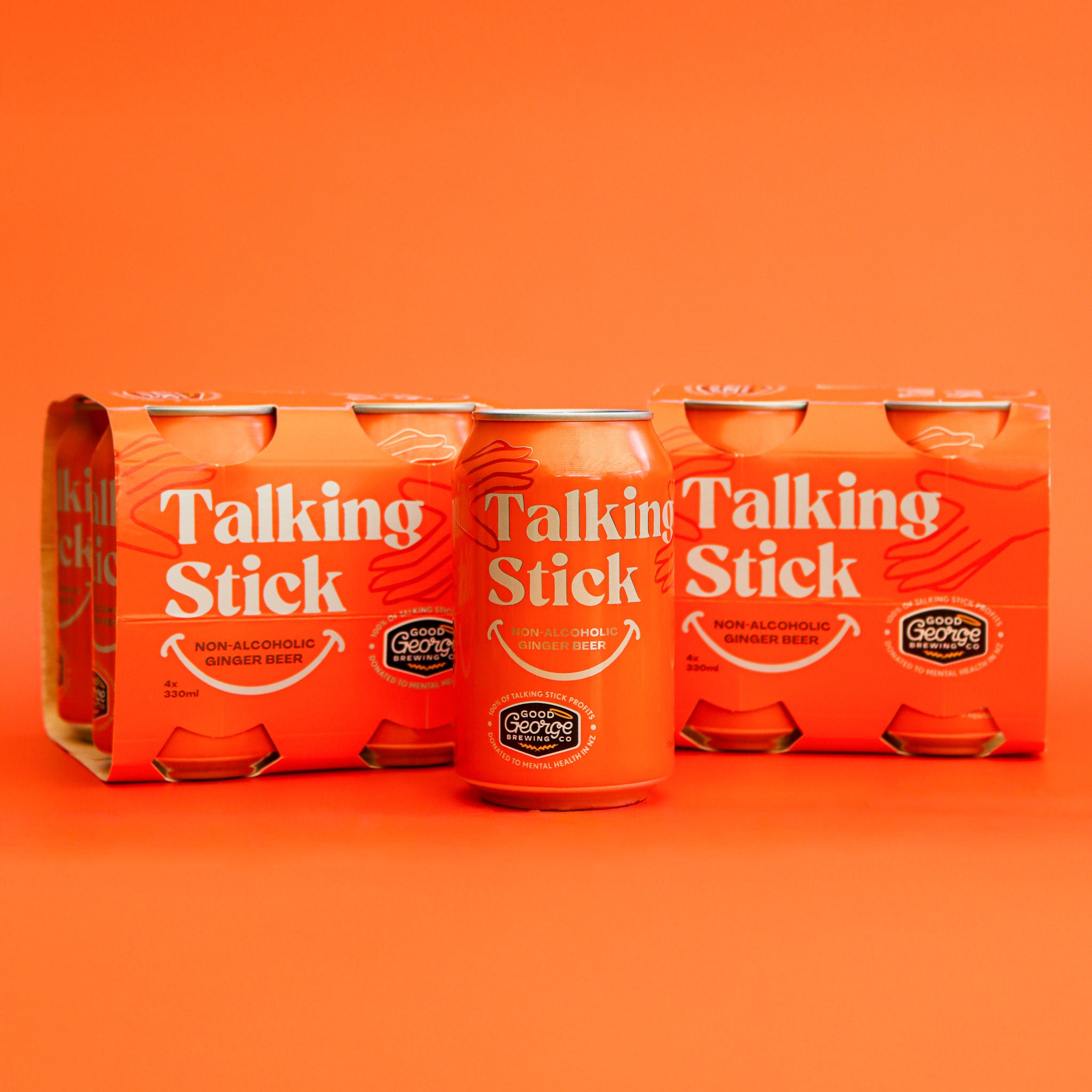 Three Talking Stick ginger beer cans on an orange background