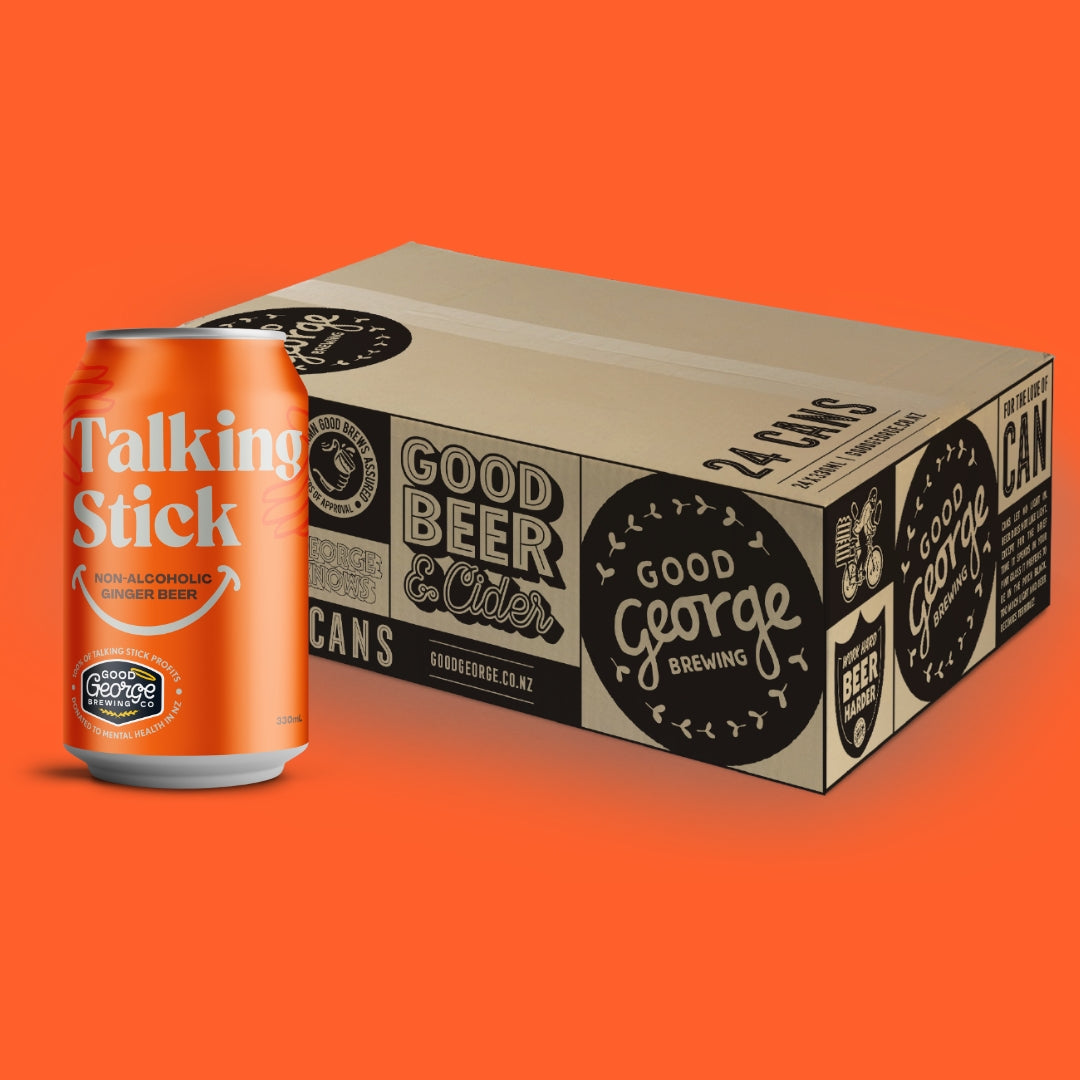 A 24-count cardboard case of Good George Brewing 'Talking Stick' non-alcoholic winter beer, shown next to a single orange aluminum can with white lettering, on a solid orange background.