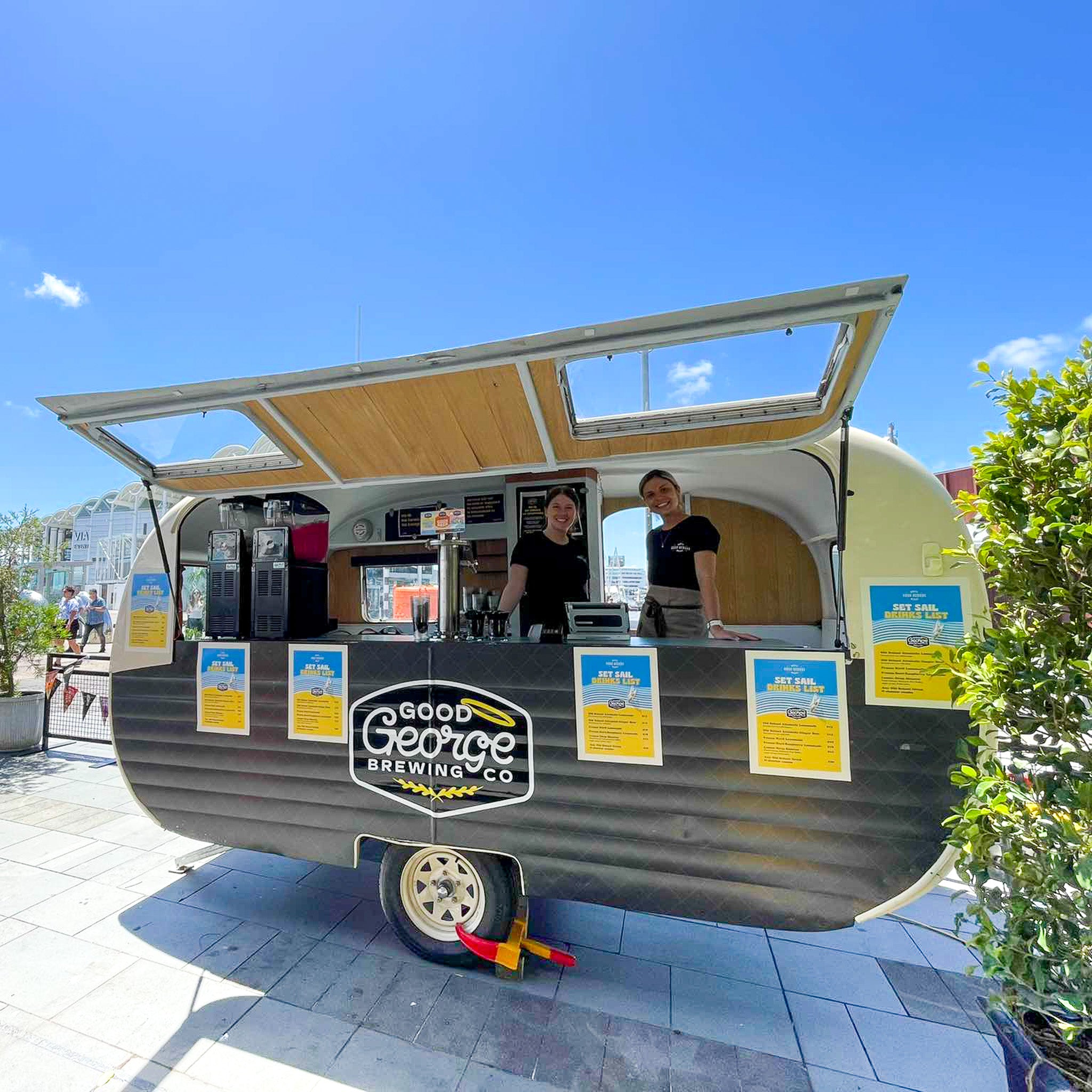 Mobile bar with 'Good George Brewing Co' branding on a sunny day.